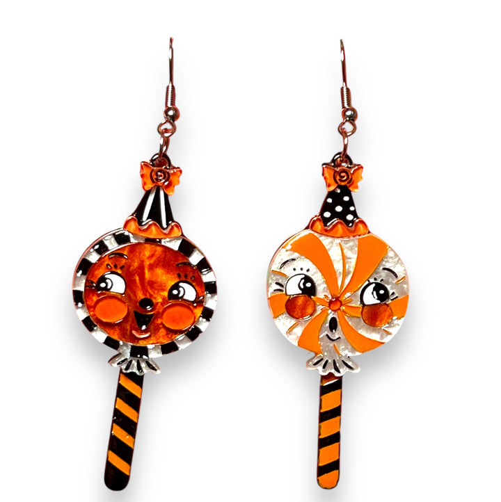 johanna parker halloween sweet treats lollipop earrings - A pair of statement earrings featuring a lollipop design with facial expressions in orange and black colors.