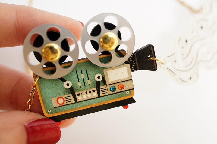 Ghost film projector necklace close-up — articulated Halloween cinema acrylic jewelry — LaliBlue Midnight Cinema