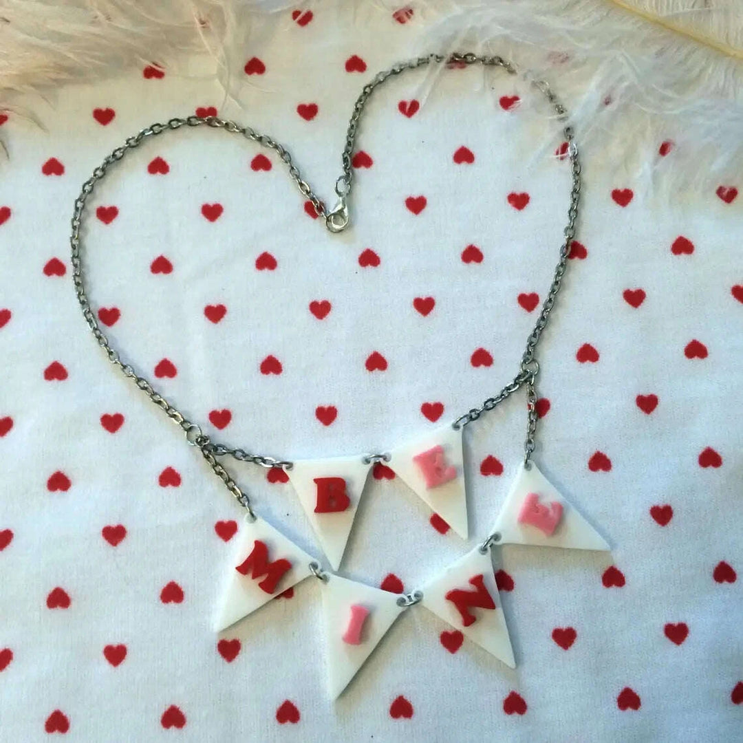 Necklace with heart-shaped pendants on a white background with red heart patterns