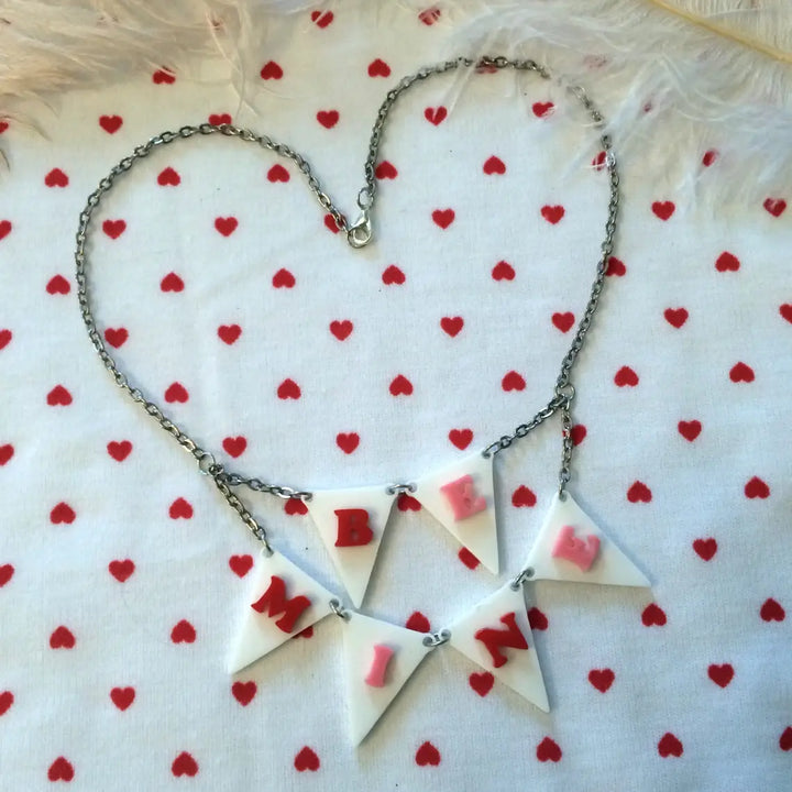 Necklace with heart-shaped pendants on a white background with red heart patterns