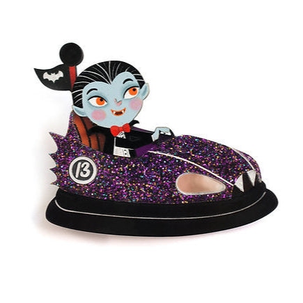 Full speed into the night! A fun-loving vampire at the wheel of a purple bumper car, ready to wreak havoc at our most monstrous fair.


 -Made of illustrated wood

 -Glitter acrylic and metallic effect
-Size: 6.5 x 6 cm

 -Safety lock on the back

 -Lightweight and comfortable to wear


 A brooch with a mischievous spirit and Halloween sparkle, ideal for horror lovers.


 Original illustration and design by LaliBlue. 