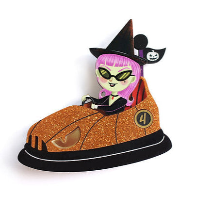 This little witch has parked her broom and hopped on the bumper car! With her orange stroller and pointy hat flying in the wind, she's spreading spells and enchanted crashes all over the fair.


 A fun, magical, and characterful brooch to shine on Halloween (and all year round!).


 -Made of illustrated wood

 -Glitter acrylic and metallic effect
-Size: 6.5 x 7 cm

 -Safety lock on the back

 -Lightweight and comfortable to wear


 A brooch with a mischievous spirit and Halloween sparkle.


 Original illust