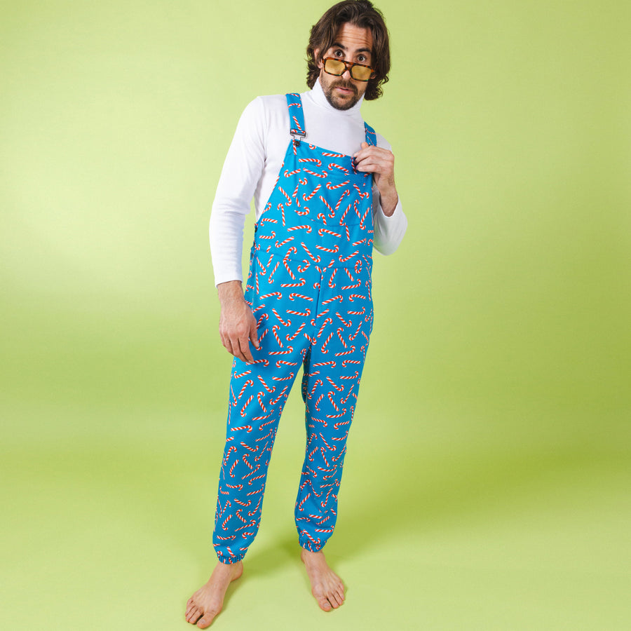 Person wearing blue patterned overalls on a green background