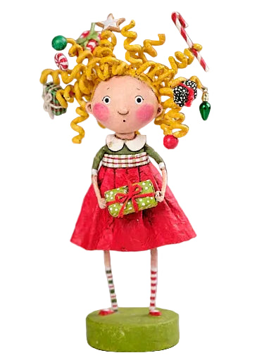 Decorative figurine of a girl with yellow hair, red dress, and candy cane in a Christmas setting.