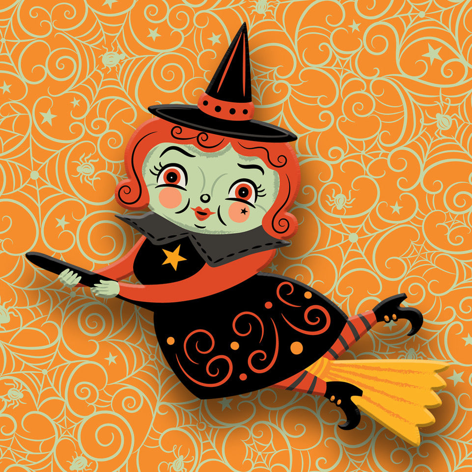 Halloween-themed decorative item with a witch design on an orange patterned background johanna parker broomhilda witch brooch
