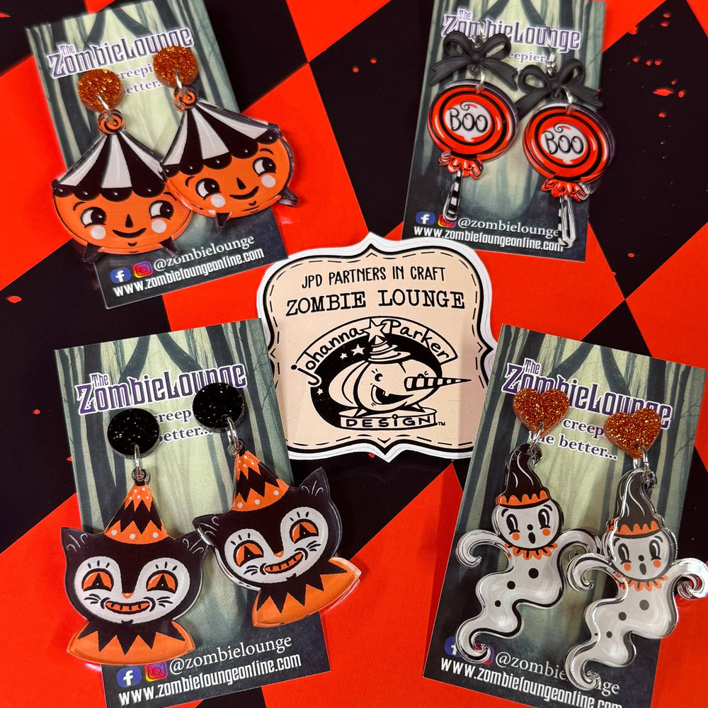 Set of Halloween-themed earrings with packaging on a red and black checkered background
