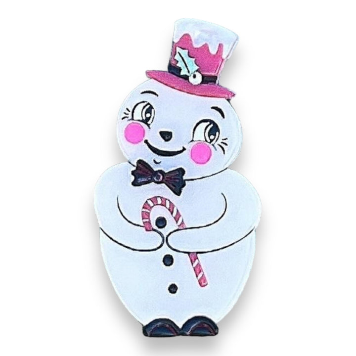 A colorful brooch depicting a snowman with a pink hat and scarf, holding a candy cane, designed by Johanna Parker.