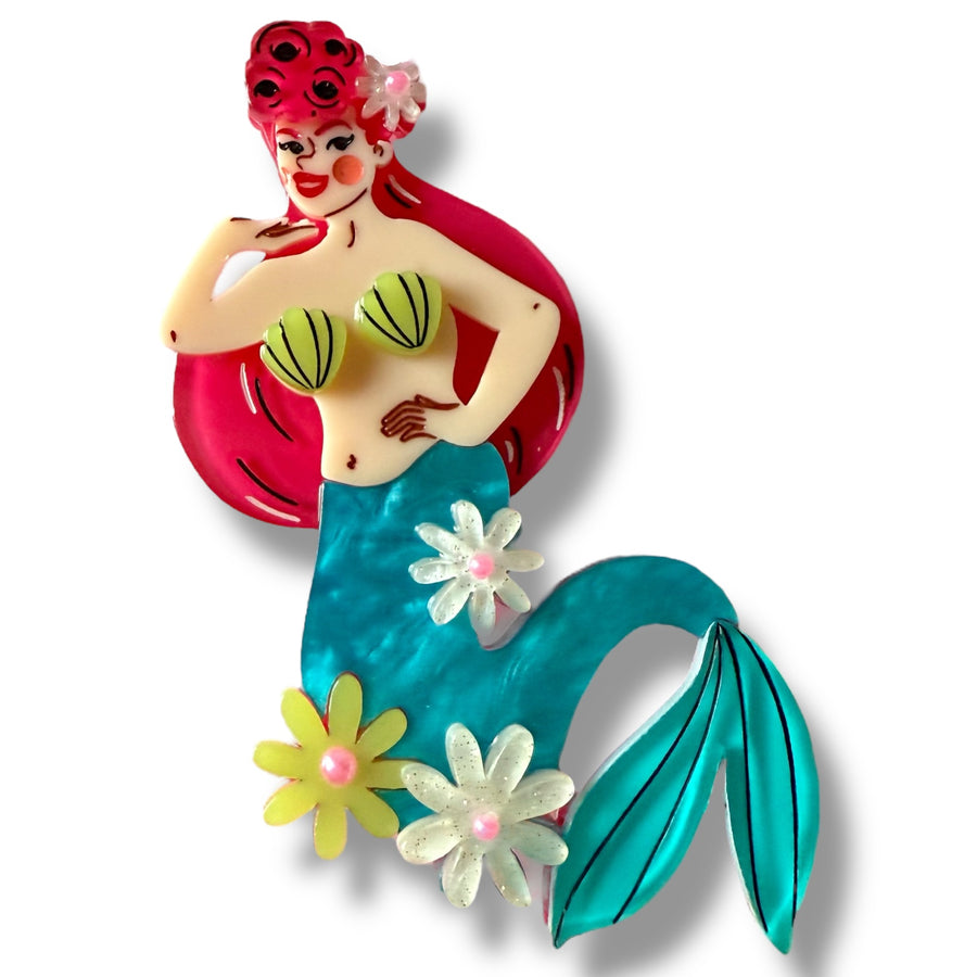 Colorful mermaid figurine with red hair and a blue tail on a white background