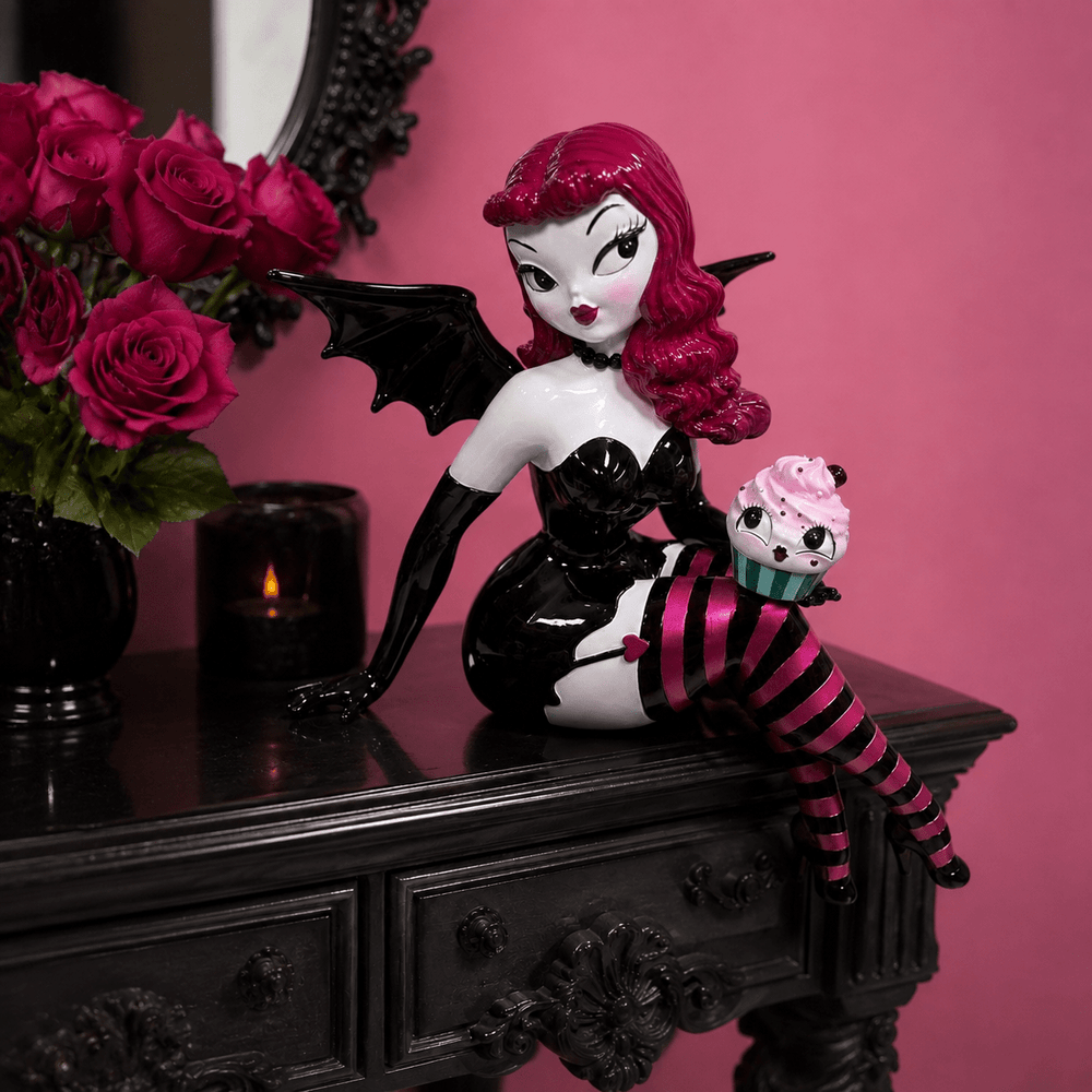 Meet Verna Bat Girl, one of the showstoppers from the newest Miss Fluff x December Diamonds collection. Standing an incredible 27.5 inches tall, she’s equal parts spooky, glamorous, and delightfully whimsical.

From her dramatic bat wings and vintage pin-up style to her striped stockings and mischievous cupcake companion, every inch is packed with the signature details Miss Fluff collectors love. Whether she’s perched on a shelf, entry table, or mant