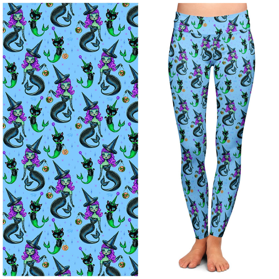 A pair of blue leggings featuring a pattern with mermaids, witches, and cats.