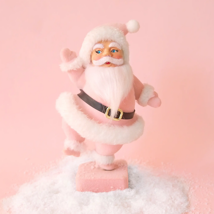 Decorative figurine of a Santa Claus on a pink background